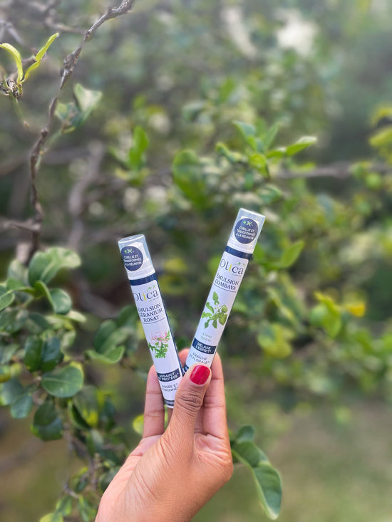 Une main tenant une émulsion Olica de Géranium Rosat et une émulsion Olica de Combava